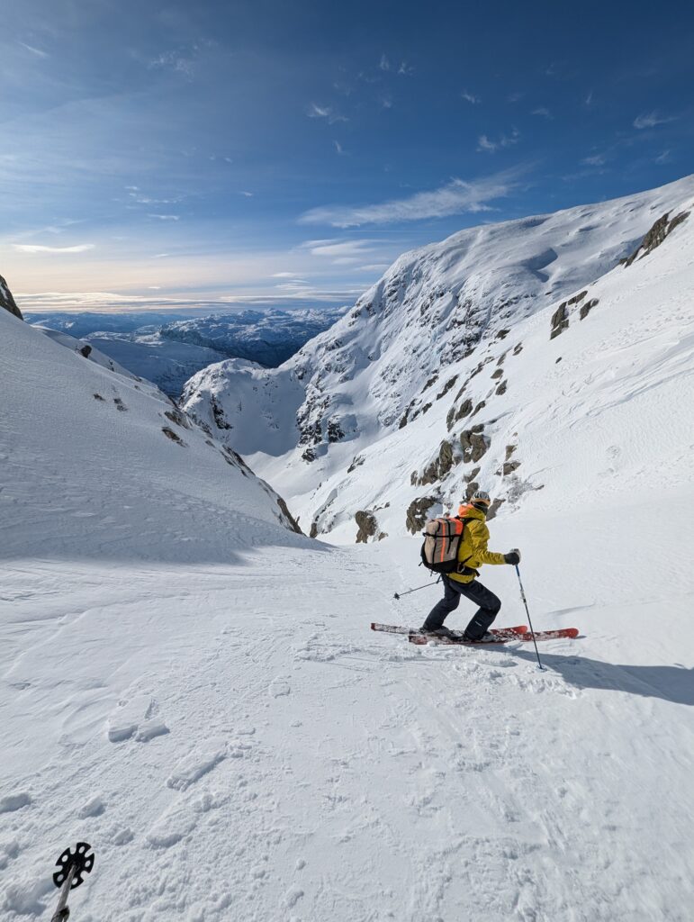 Skikjøre ser ned bratt renne før han kjøre. Toppturkurs på Voss – kurs i skiteknikk, skred og alpint terreng